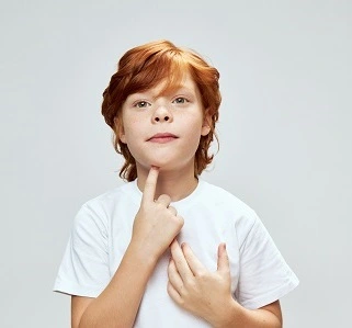 Logopädie Bautzen kindliche_Stimmstörung Bild zeigt Kind das mit mit seinem Zeigefinger auf den Kehlkopf zeigt