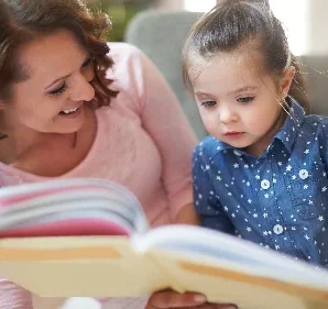 Logopädie Bautzen Wortschatz Bild zeigt eine Mami die Ihrem Kind vorließt wodurch sich der Wortschatz erweitert