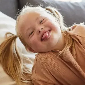 Logopädie Bautzen myofunktionelle Störung Kinder Bild zeigt Kind mit Downsyndrom das die Zunge rausstreckt